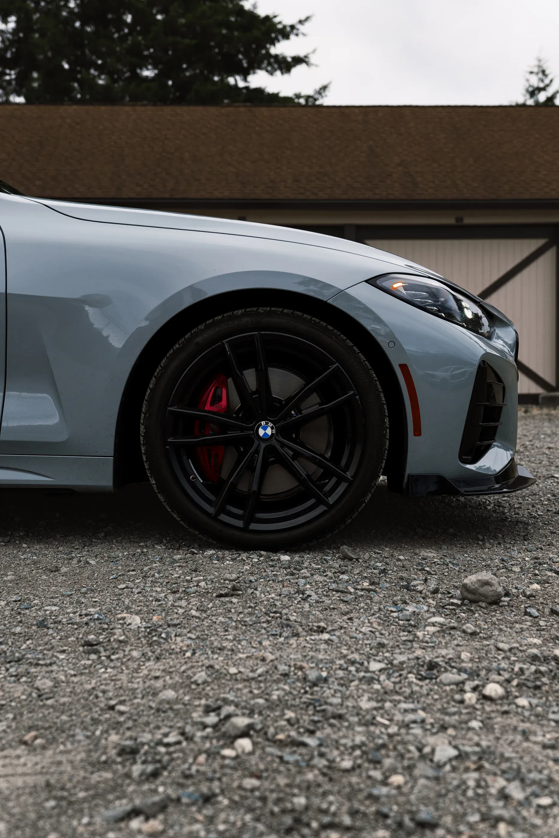 Detail of the front wheel and red brake caliper on a grey BMW M440i.