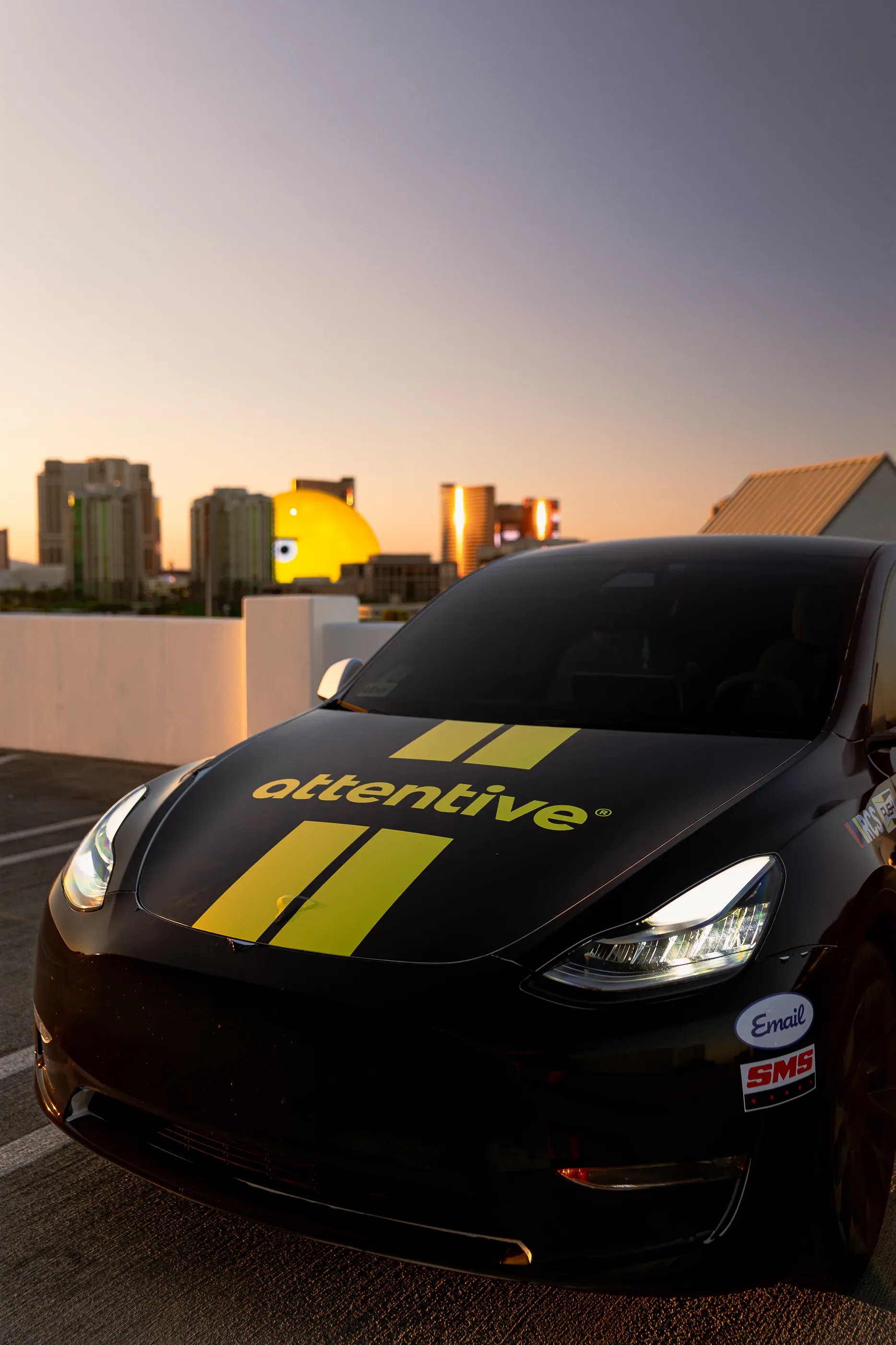 Attentive-branded car parked with the Las Vegas skyline behind it.