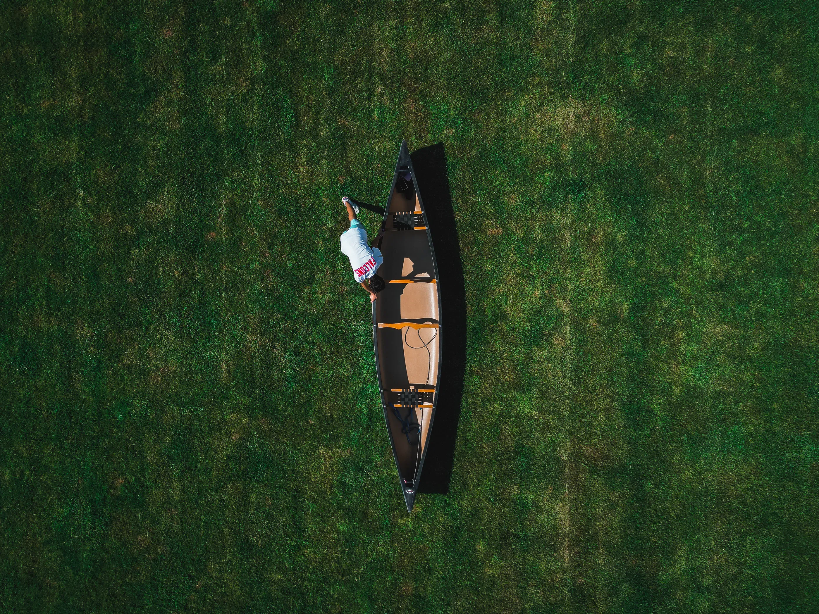 Drone view of a boat being pulled across a football field.