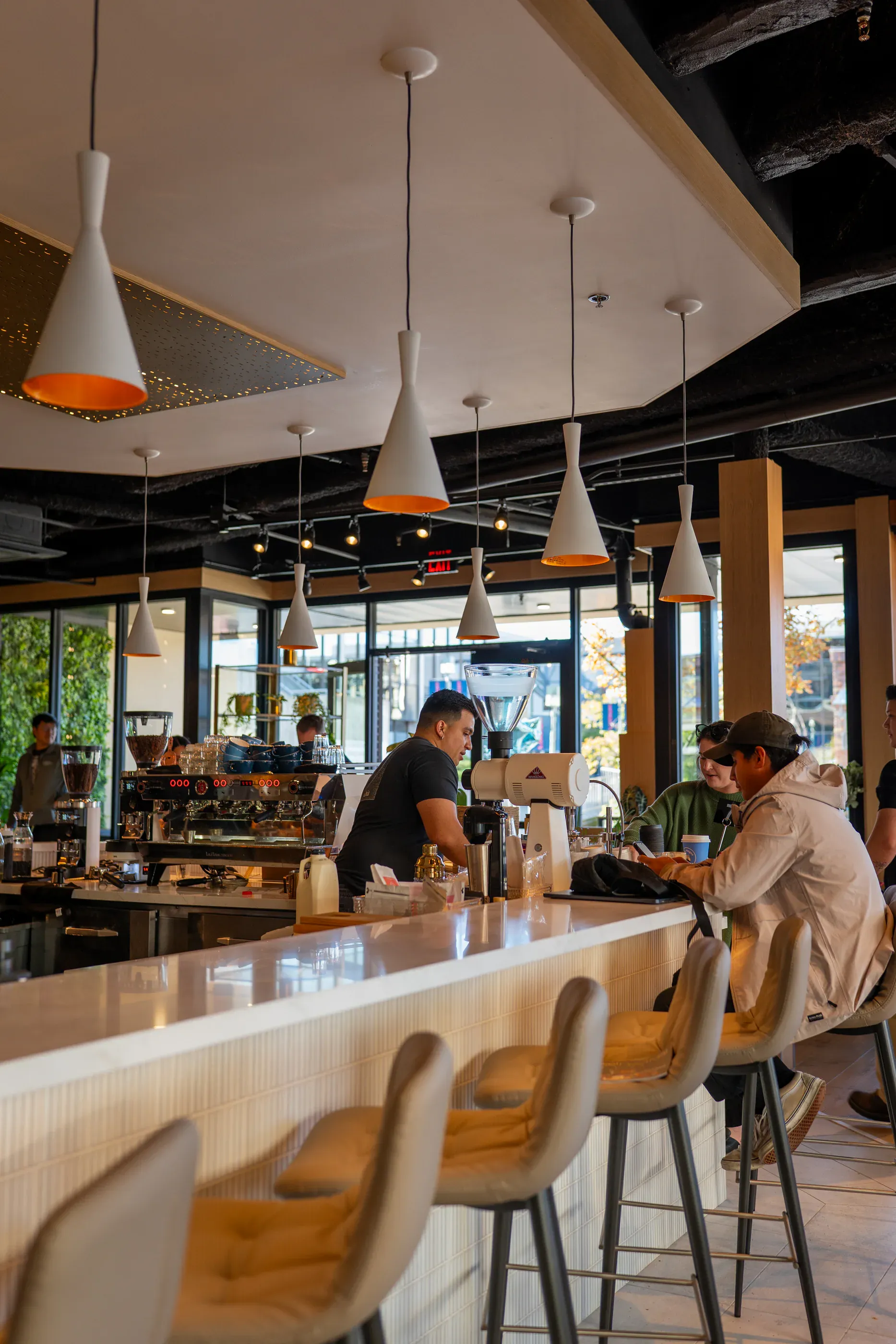 Cafe counter with pendant lights and seated guests.