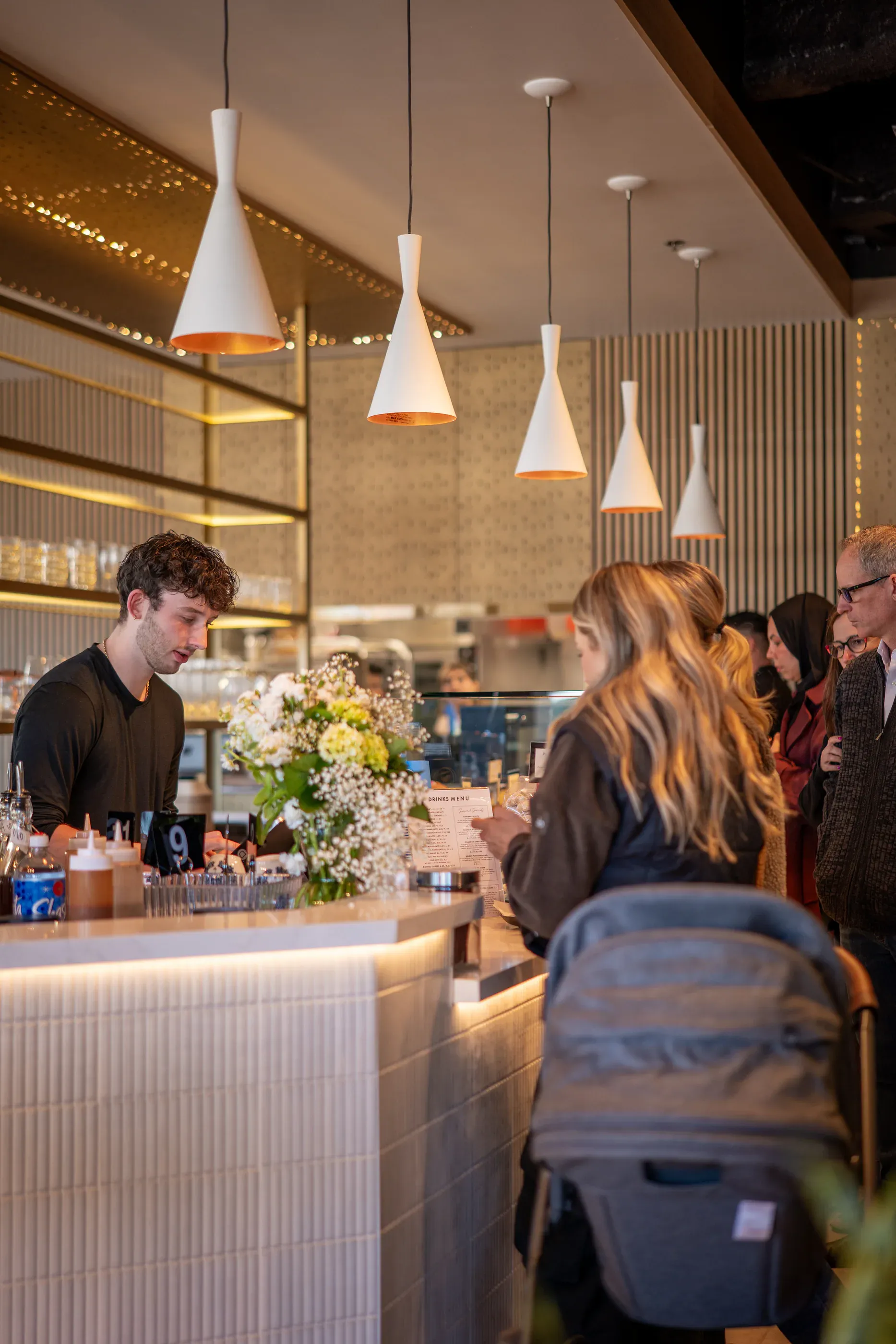 Cafe bar area with staff and warm overhead lighting.