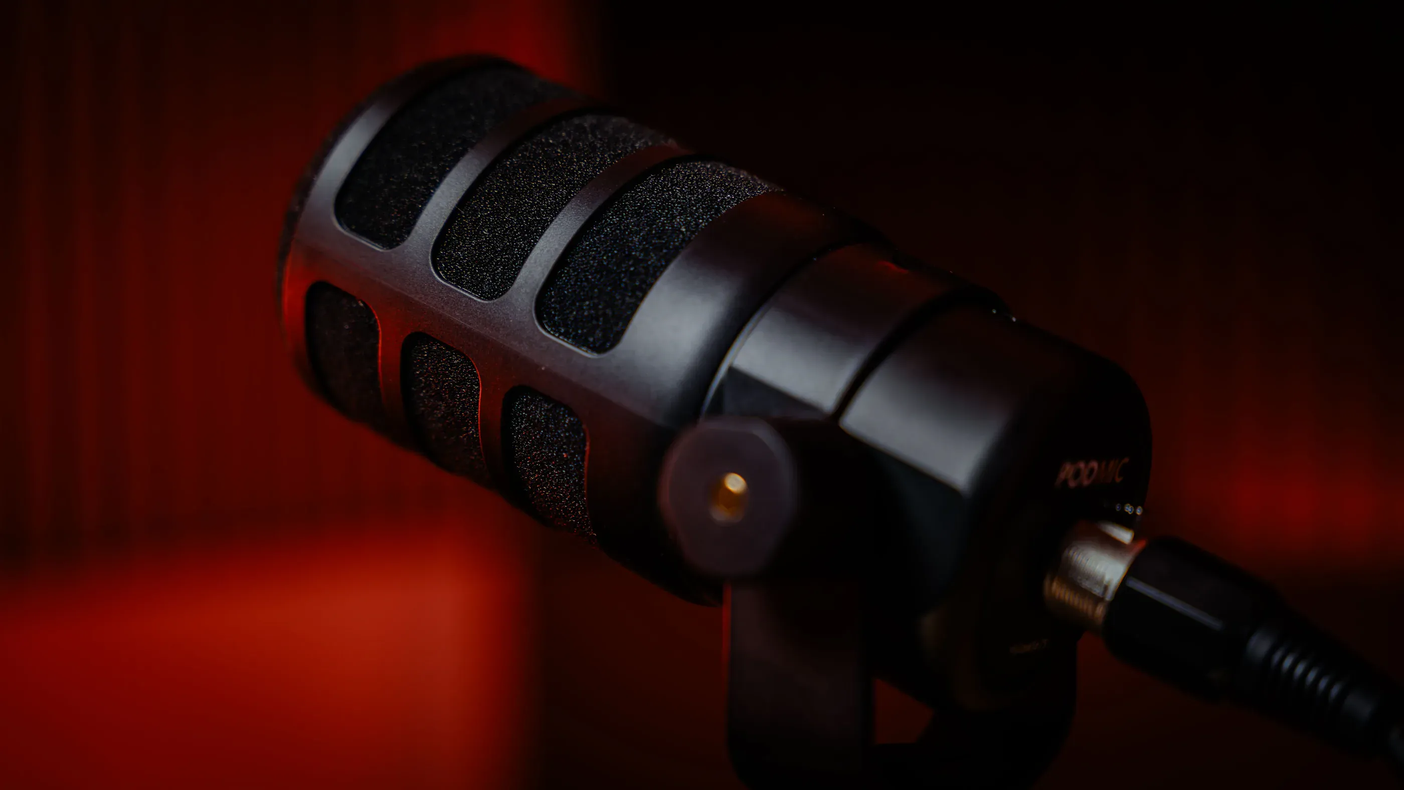 Close view of a podcast microphone against red light.