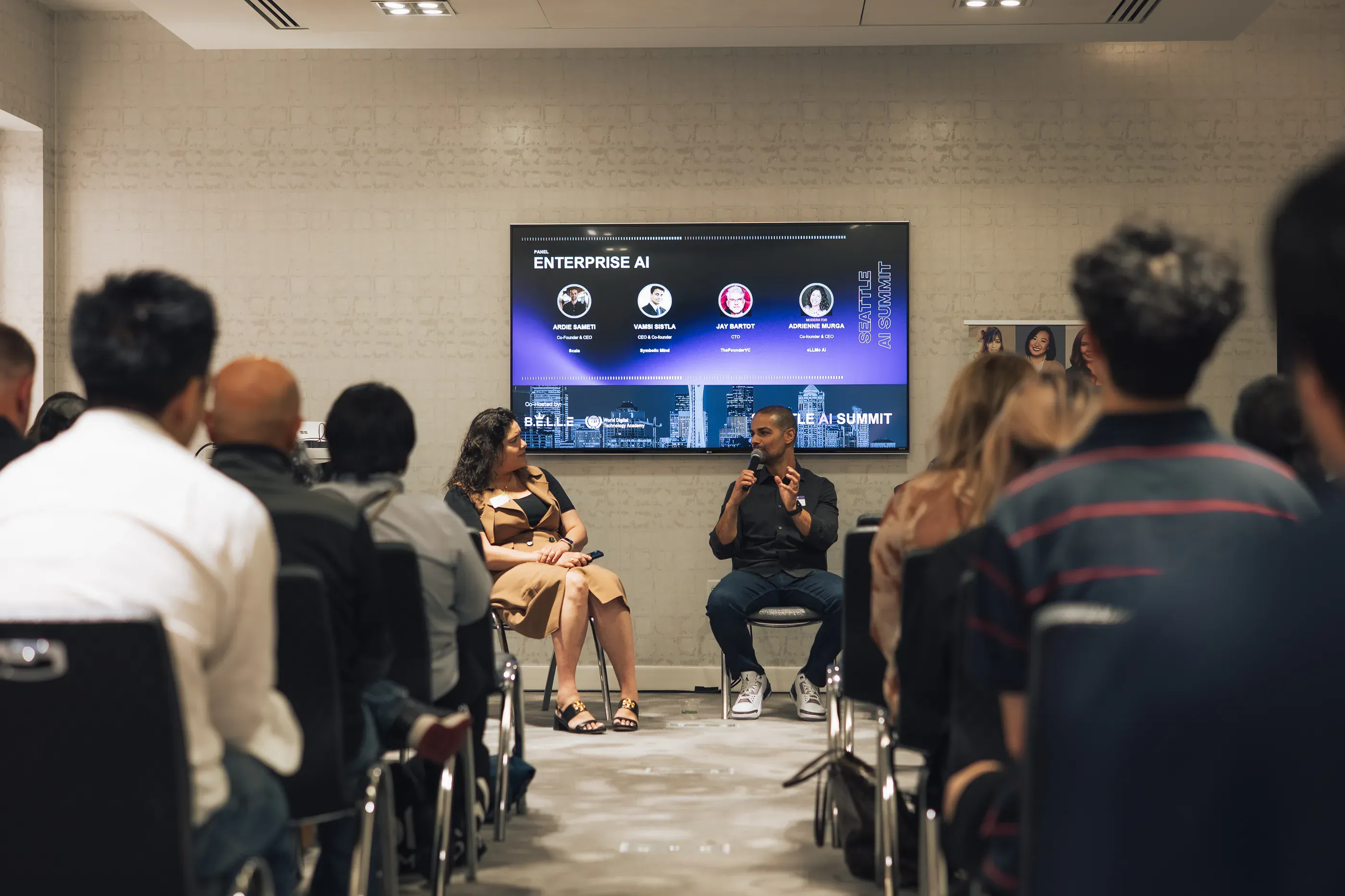 A seated panel on enterprise AI in a breakout room, photographed from behind the audience.