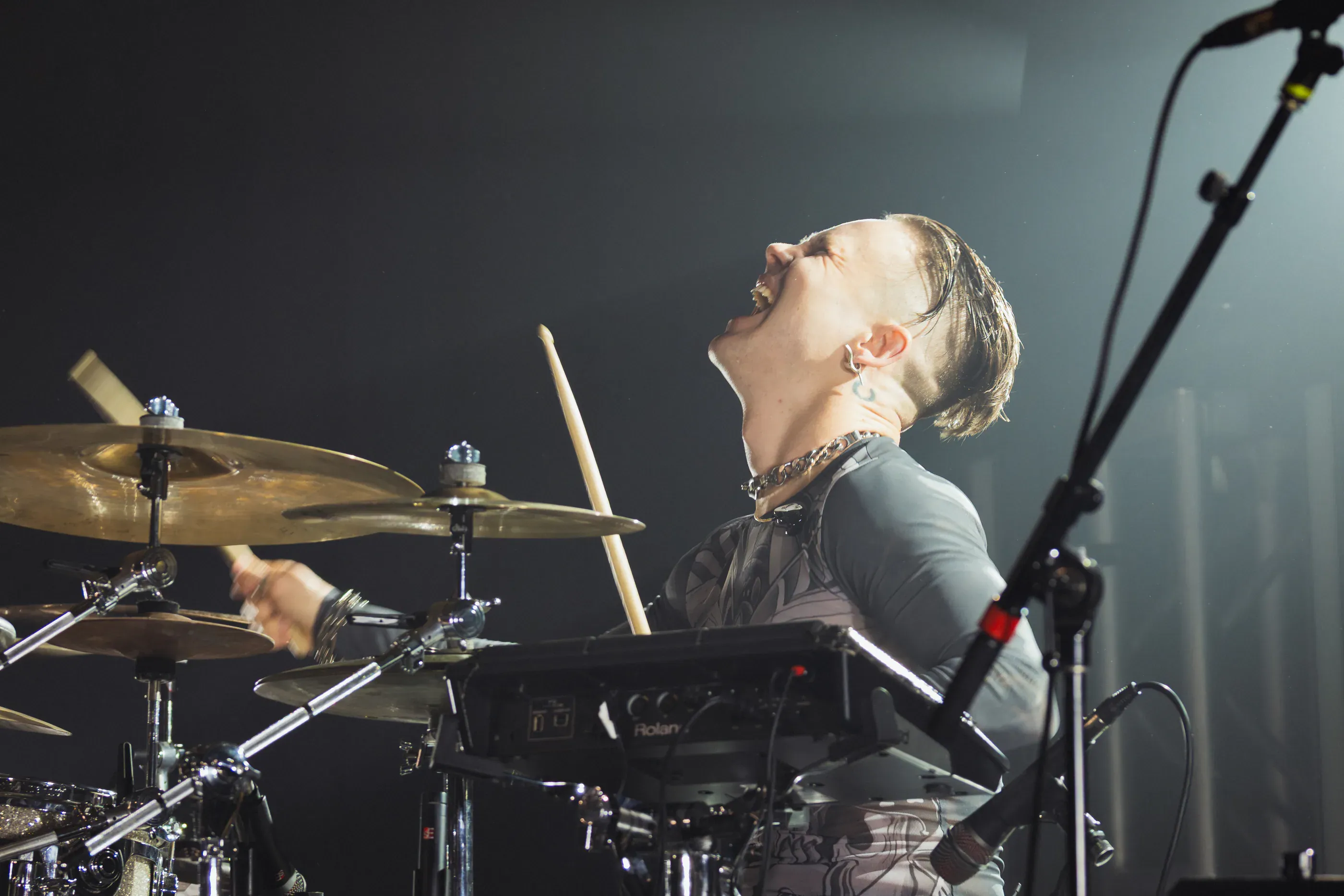 Drummer plays with head tilted back on stage.