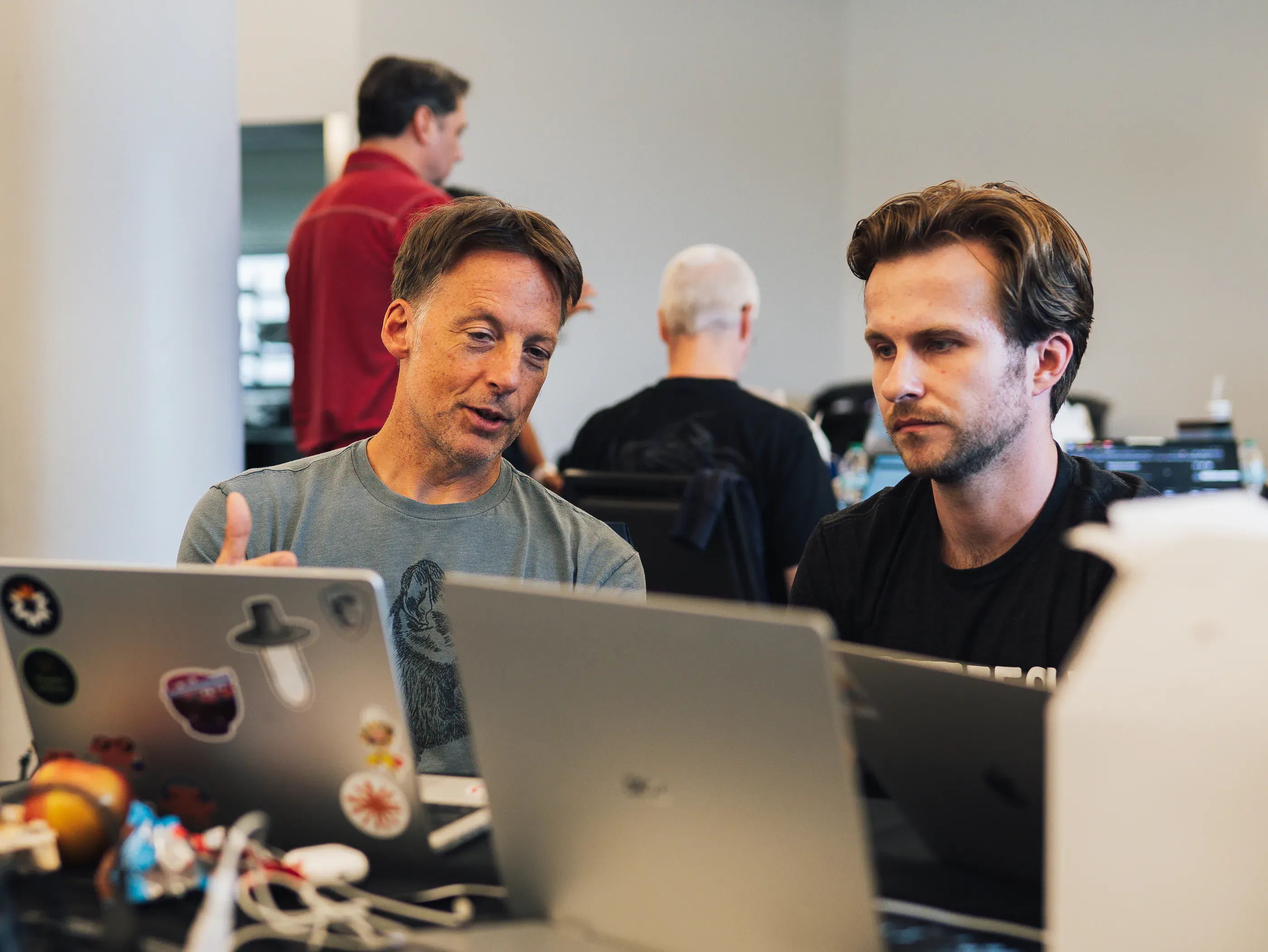 Two participants talking over open laptops during the hackathon.