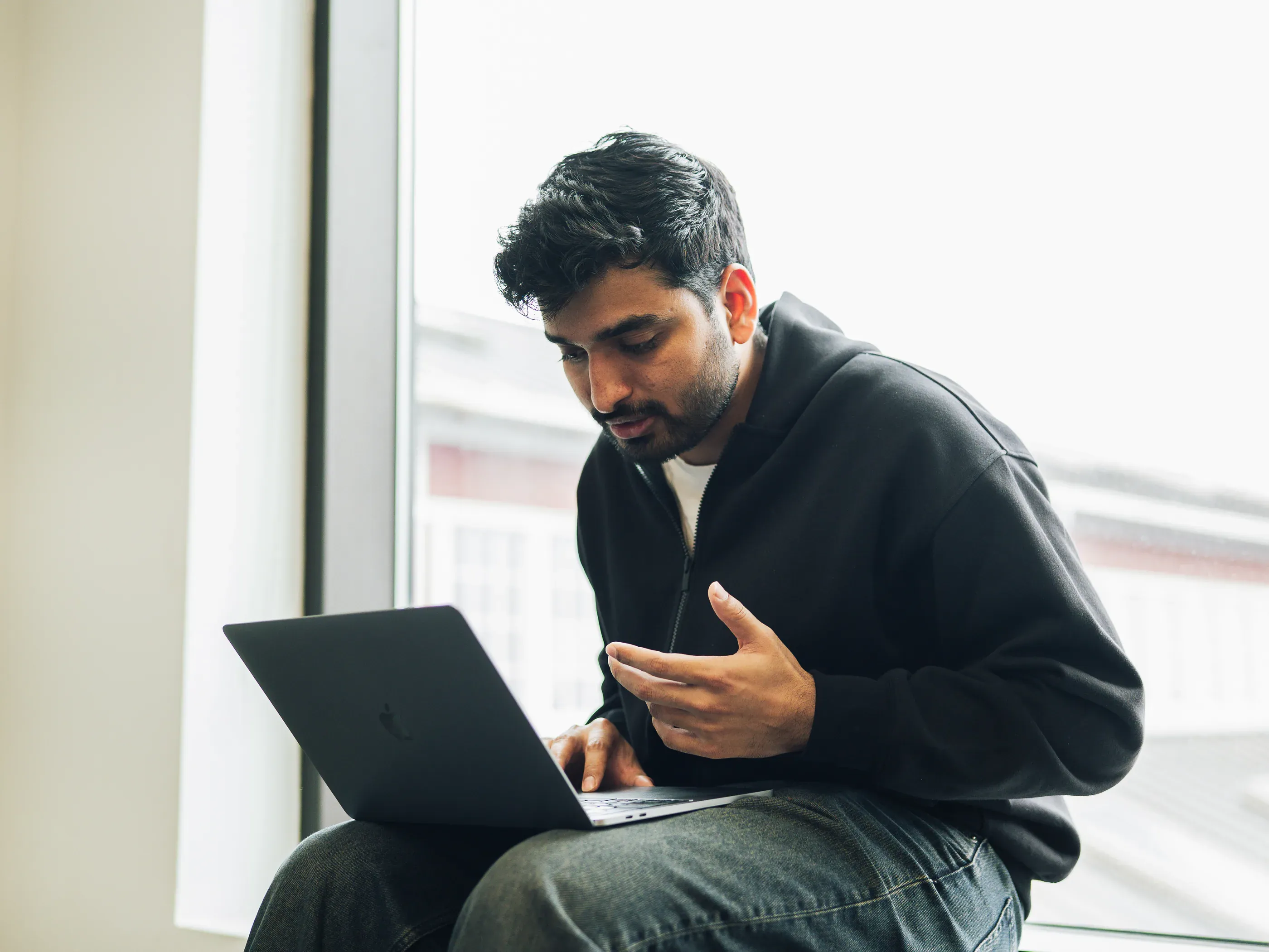 A participant working on a laptop by a window during the overnight build.