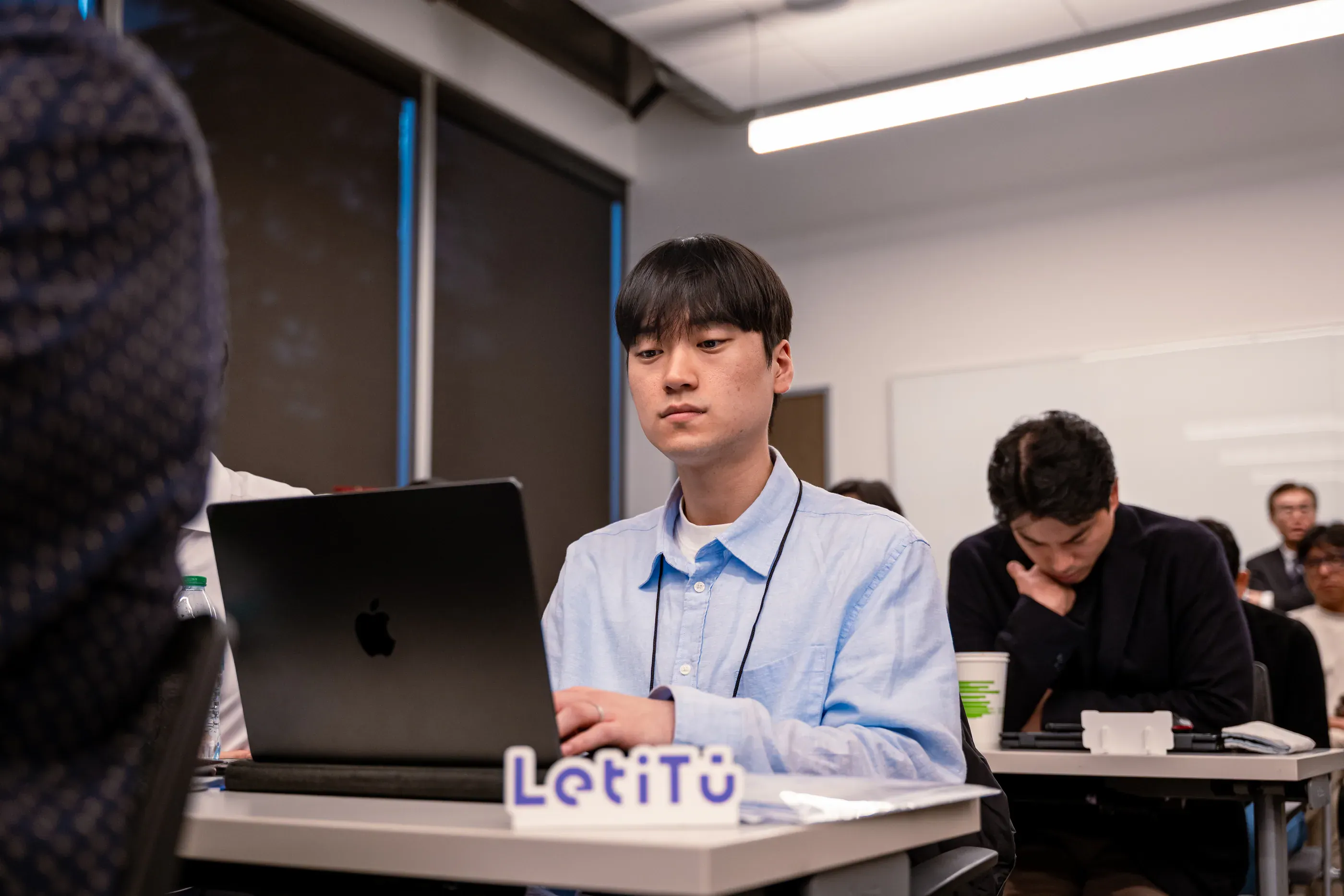 Founder sits behind a laptop during a startup pitch session.