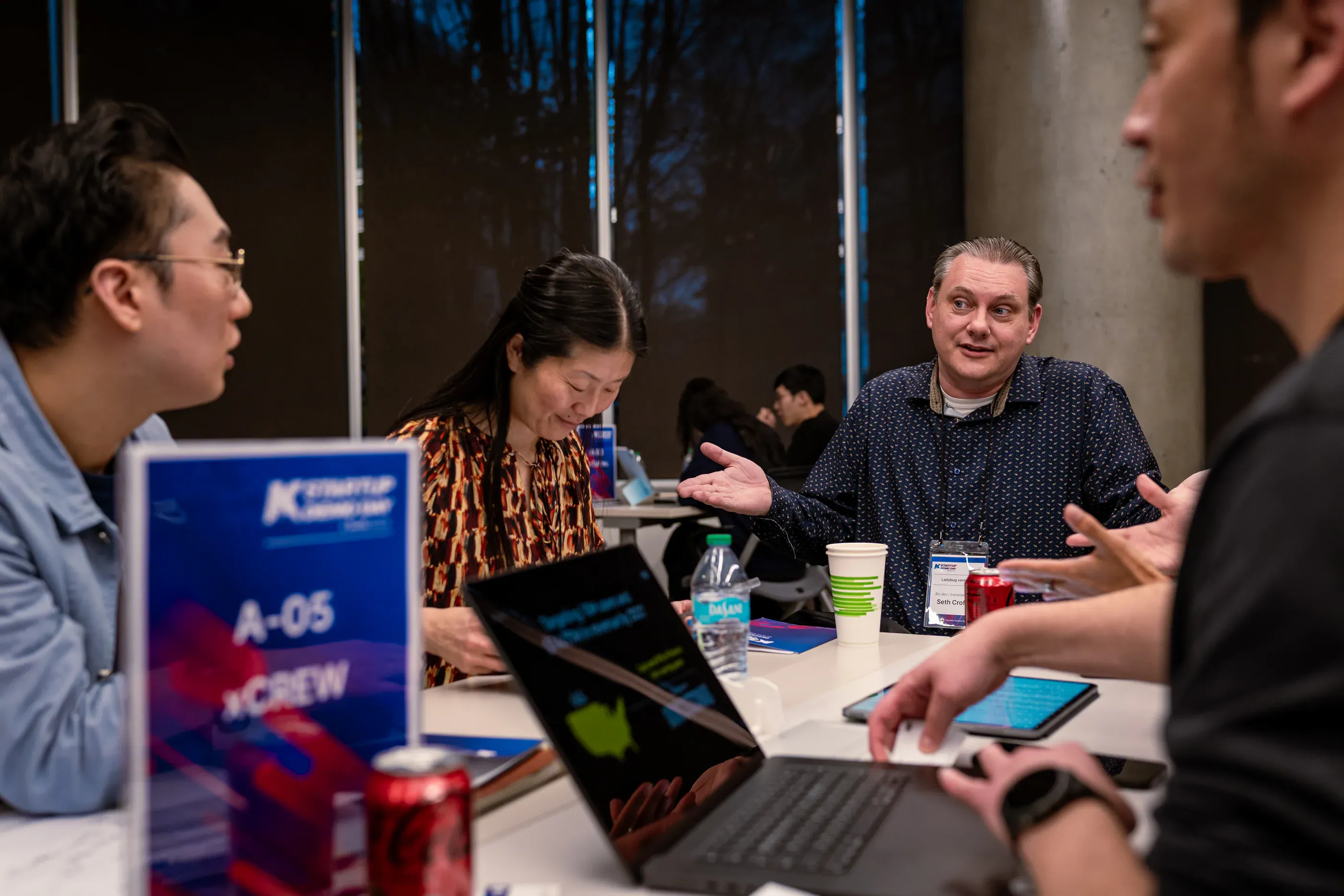 Small group discusses a startup pitch around a table.