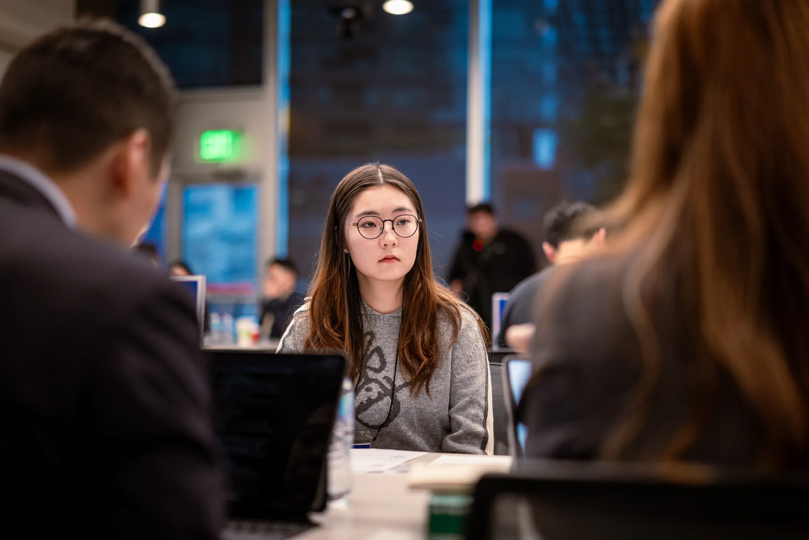 Attendee listens across a table during a group discussion.