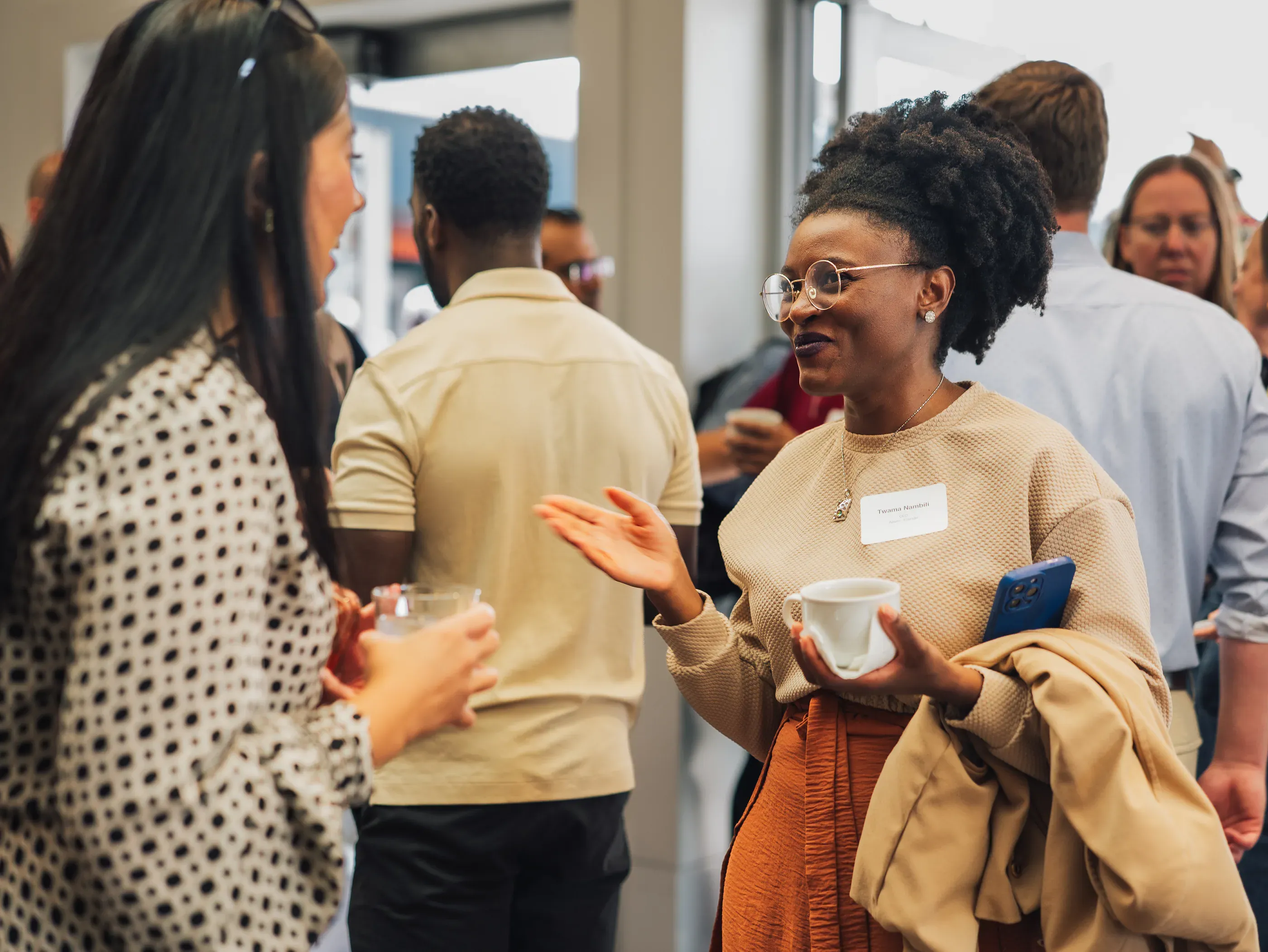 Guests in conversation over coffee during a networking break.
