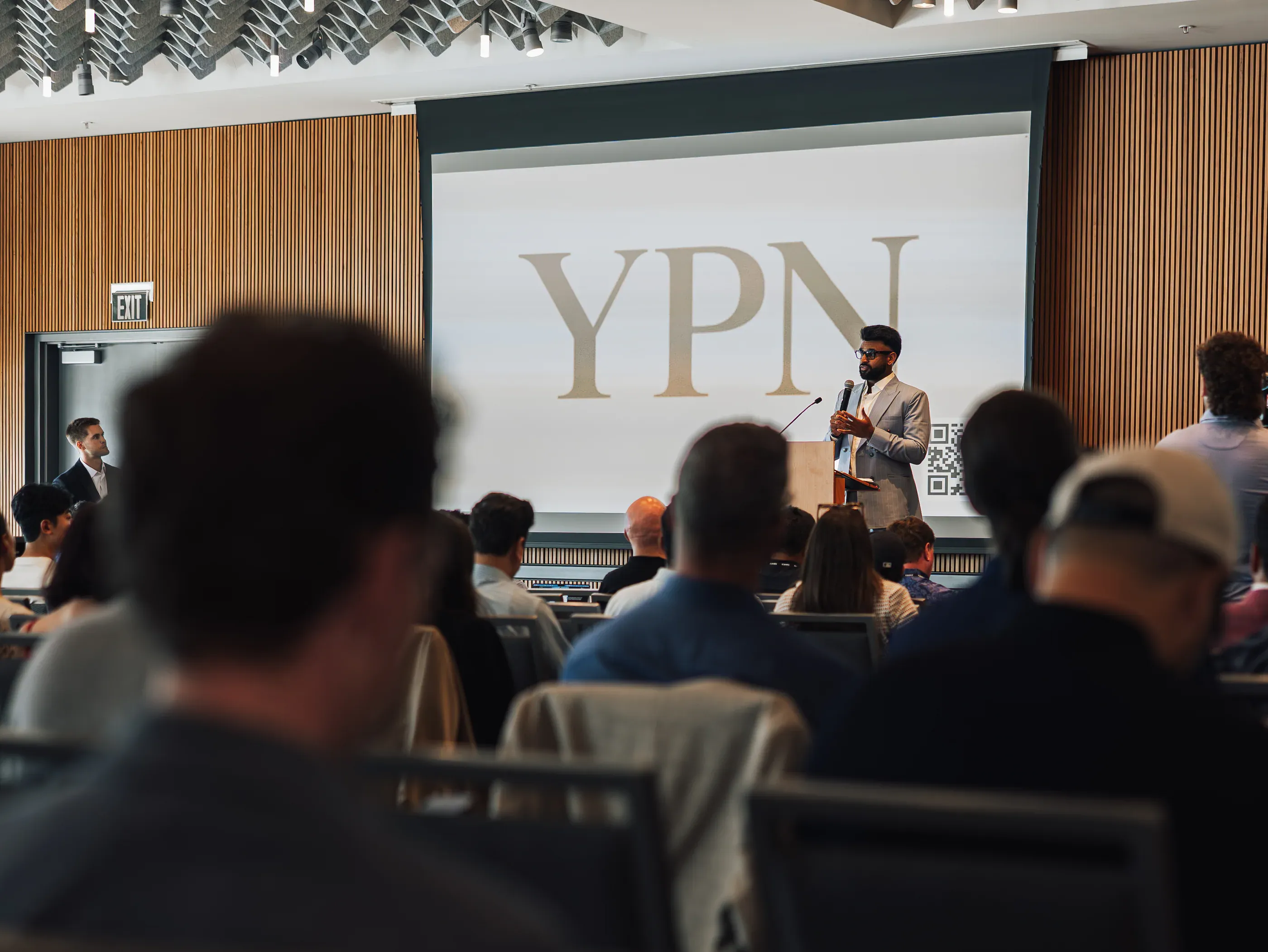 Speaker presenting at a podium during a session at a Seattle tech event.