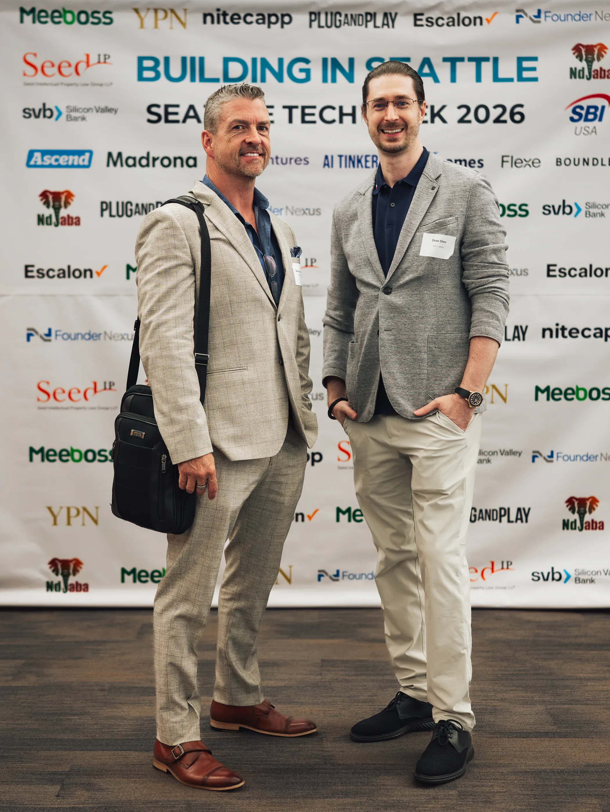 Two attendees in front of the Building in Seattle banner at Seattle Tech Week 2026.