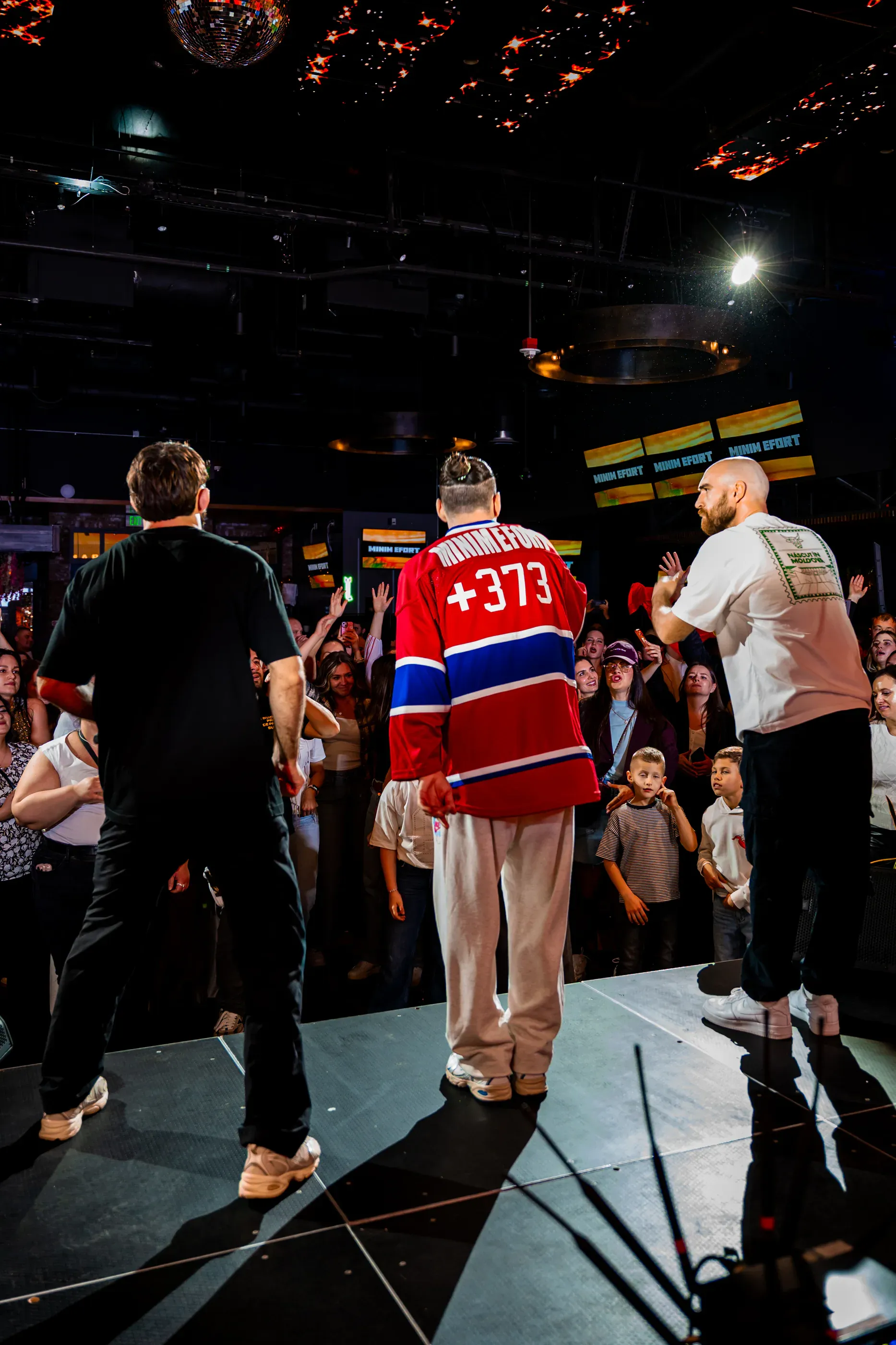 Performer walks across the stage in a red jersey.