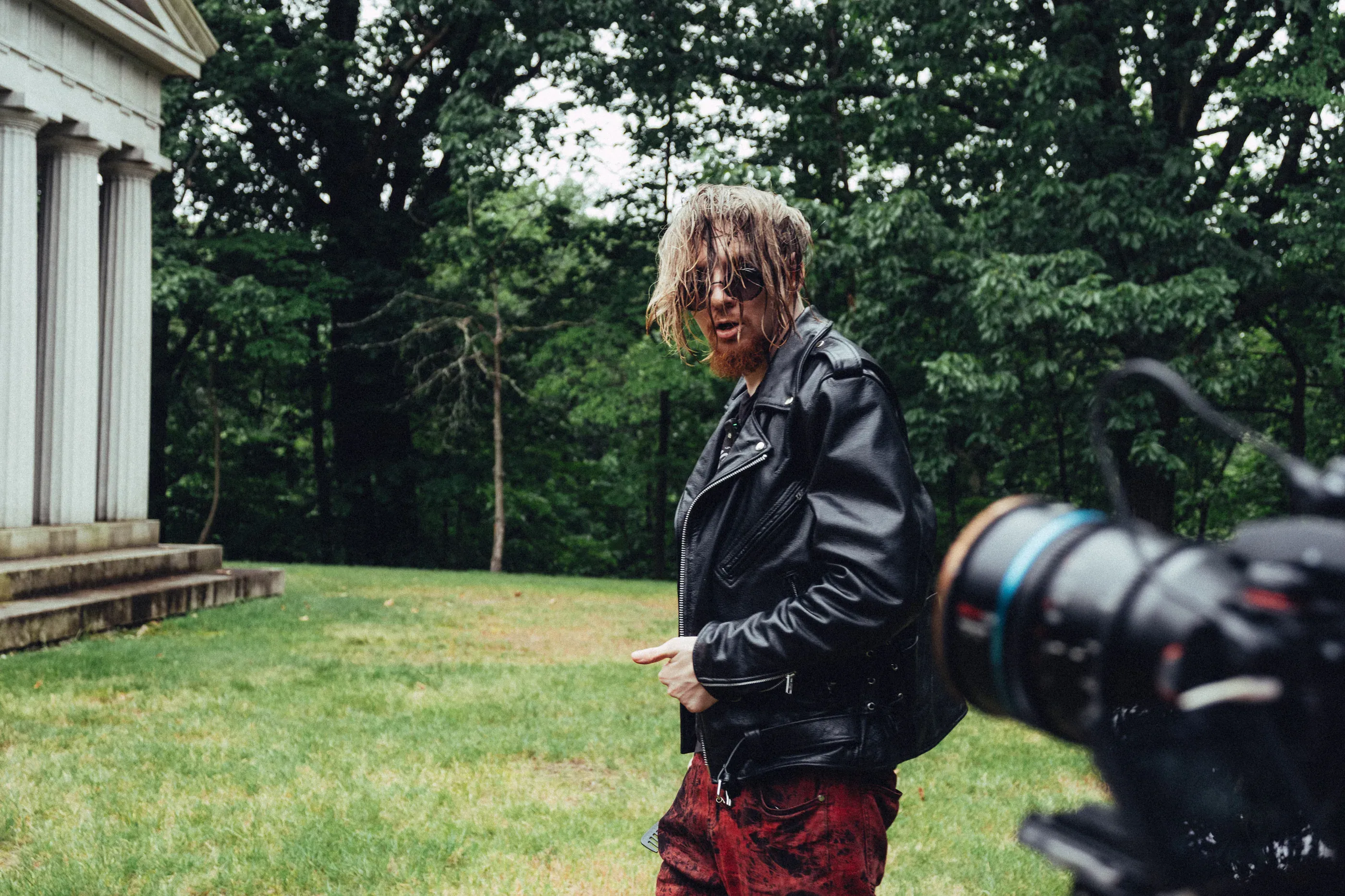 Dmitry Nuberg stands outdoors beside a camera setup.
