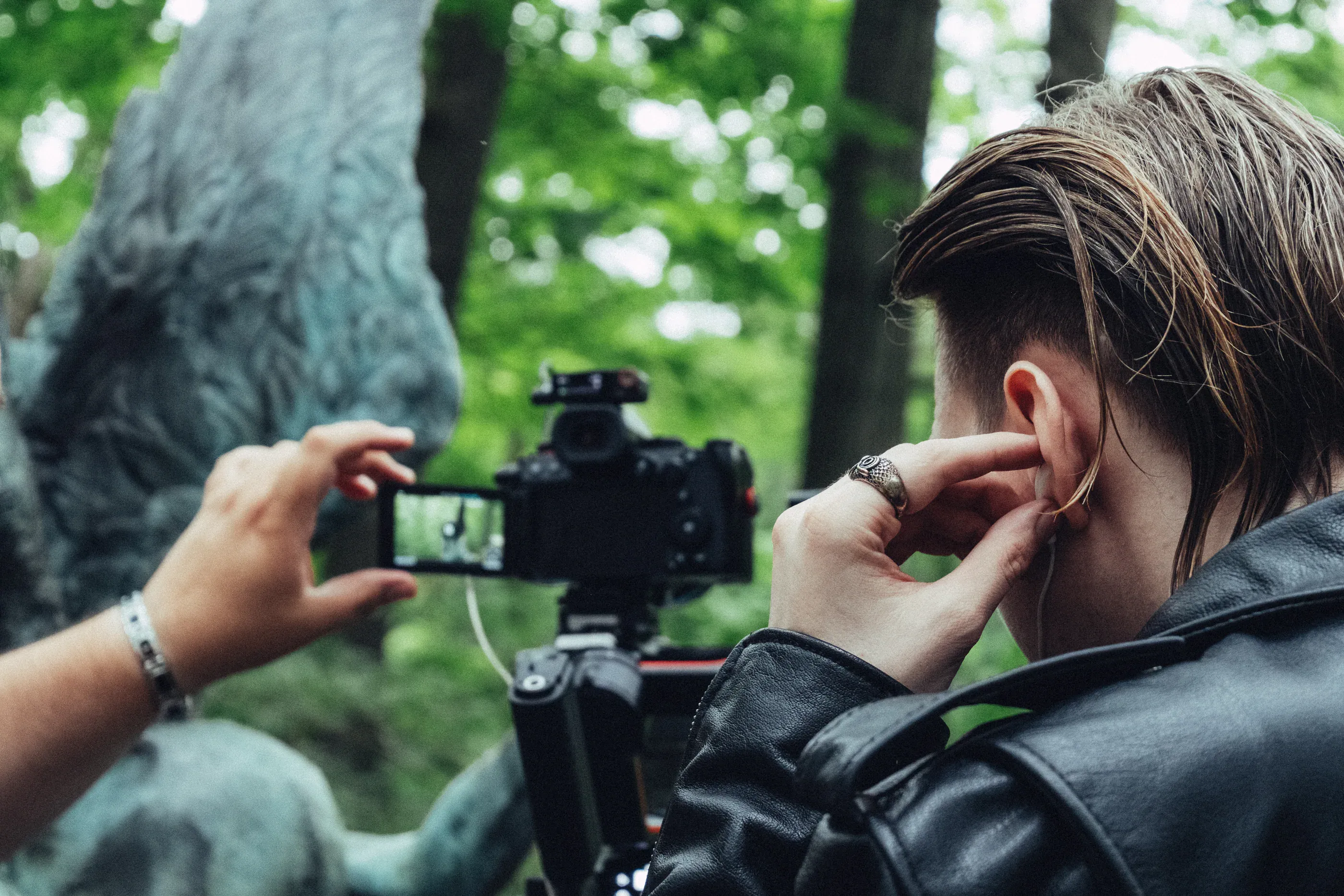 Camera operator films Dmitry Nuberg outdoors from behind.